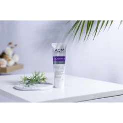 Tube de crème apaisante ACM Cicastim.A 20 ml posé sur une table avec des éléments de décoration