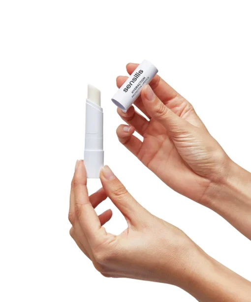 Baume à lèvres Hydraction de Sensilis ouvert, tenu par une main