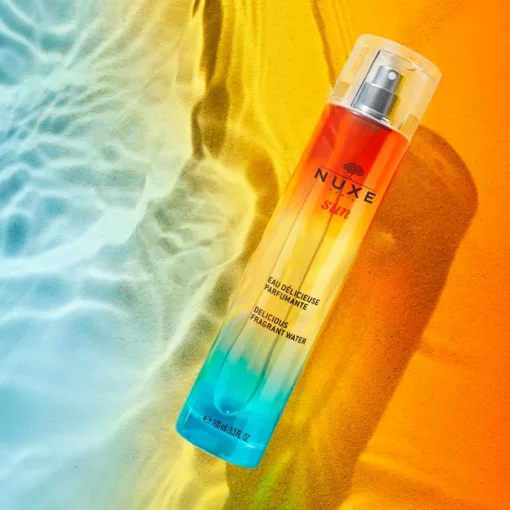 Eau délicieuse parfumante NUXE Sun 100 ml sur fond estival