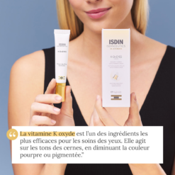 Femme tenant la crème ISDIN K-Ox Eyes et son packaging avec un applicateur effet froid.