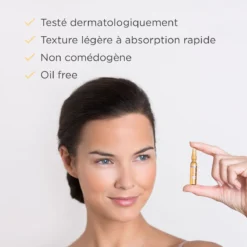 Femme tenant une ampoule ISDIN Flavo-C avec sérum non comédogène et à absorption rapide