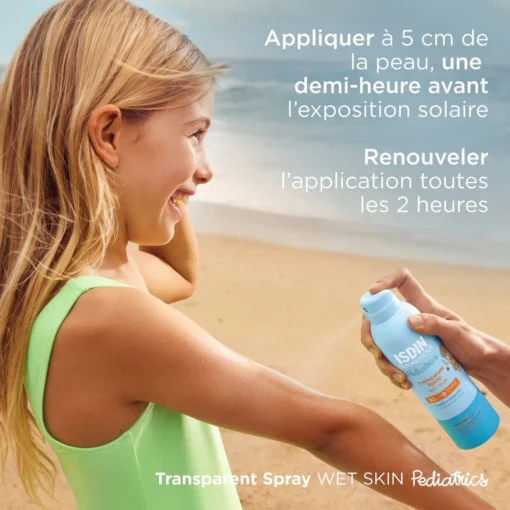 Enfant appliquant le spray solaire ISDIN Fotoprotector Pediatrics à la plage.