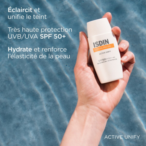 Main tenant la crème solaire ISDIN Fotoultra Active Unify SPF 50+ devant une piscine.