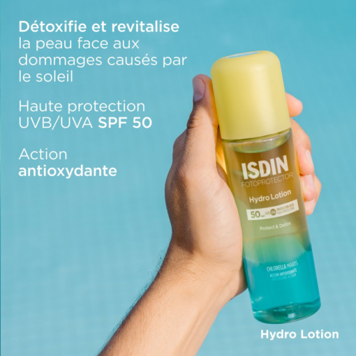 Main tenant un flacon d'ISDIN Hydro Lotion avec une protection SPF50 et une action antioxydante.