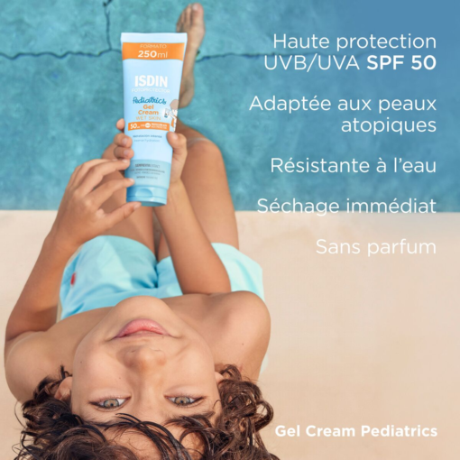 Enfant montrant le gel crème ISDIN Pediatrics SPF 50+ près de la piscine.