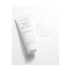 Texture de l'émulsion hydratante Avène Hydrance UV Légère SPF 30 à côté du tube.