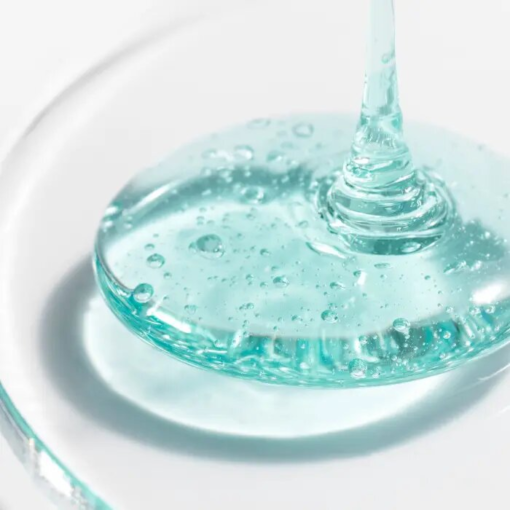 Texture du gel nettoyant Avène Cleanance avec des bulles sur une surface transparente.